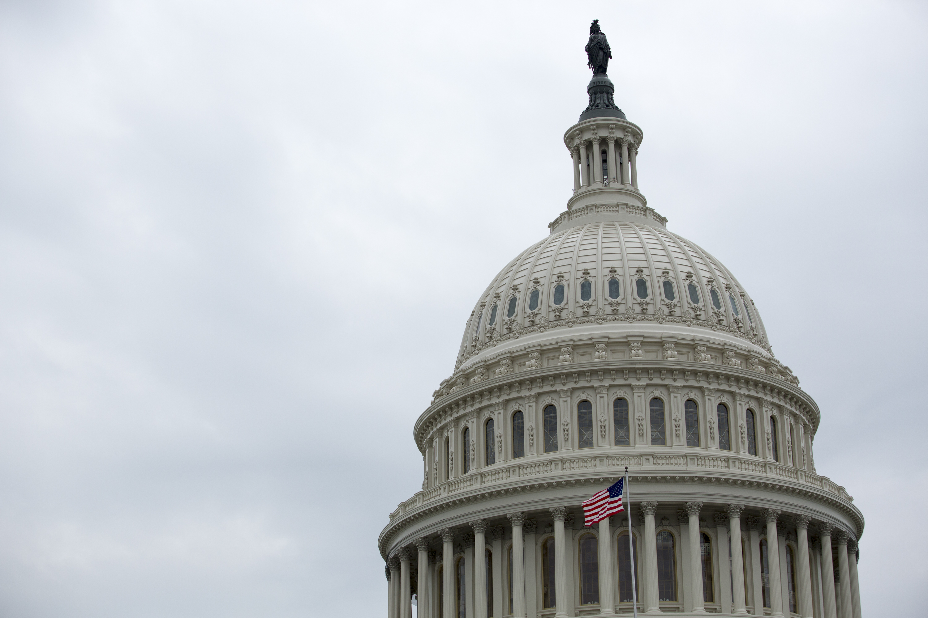 The capitol dome in Washington, DC against a cloudy sky.