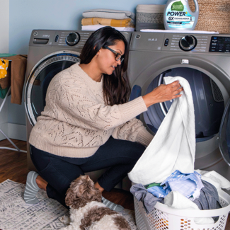 Woman loading clothes in washing machine